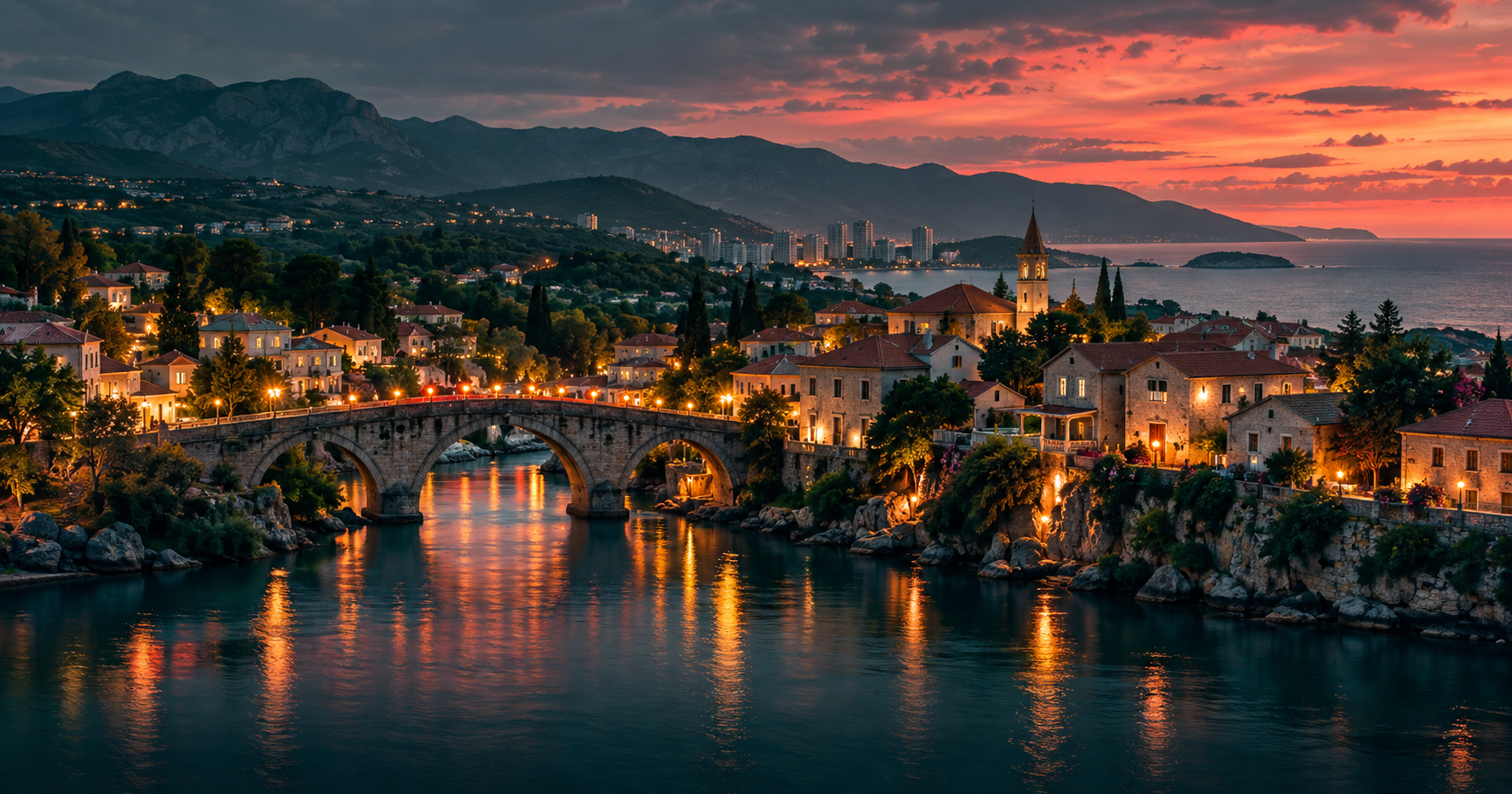 A small town on the coast at dusk: an old stone bridge over a quiet river, warm lights in the windows of little houses and green countryside hills behind